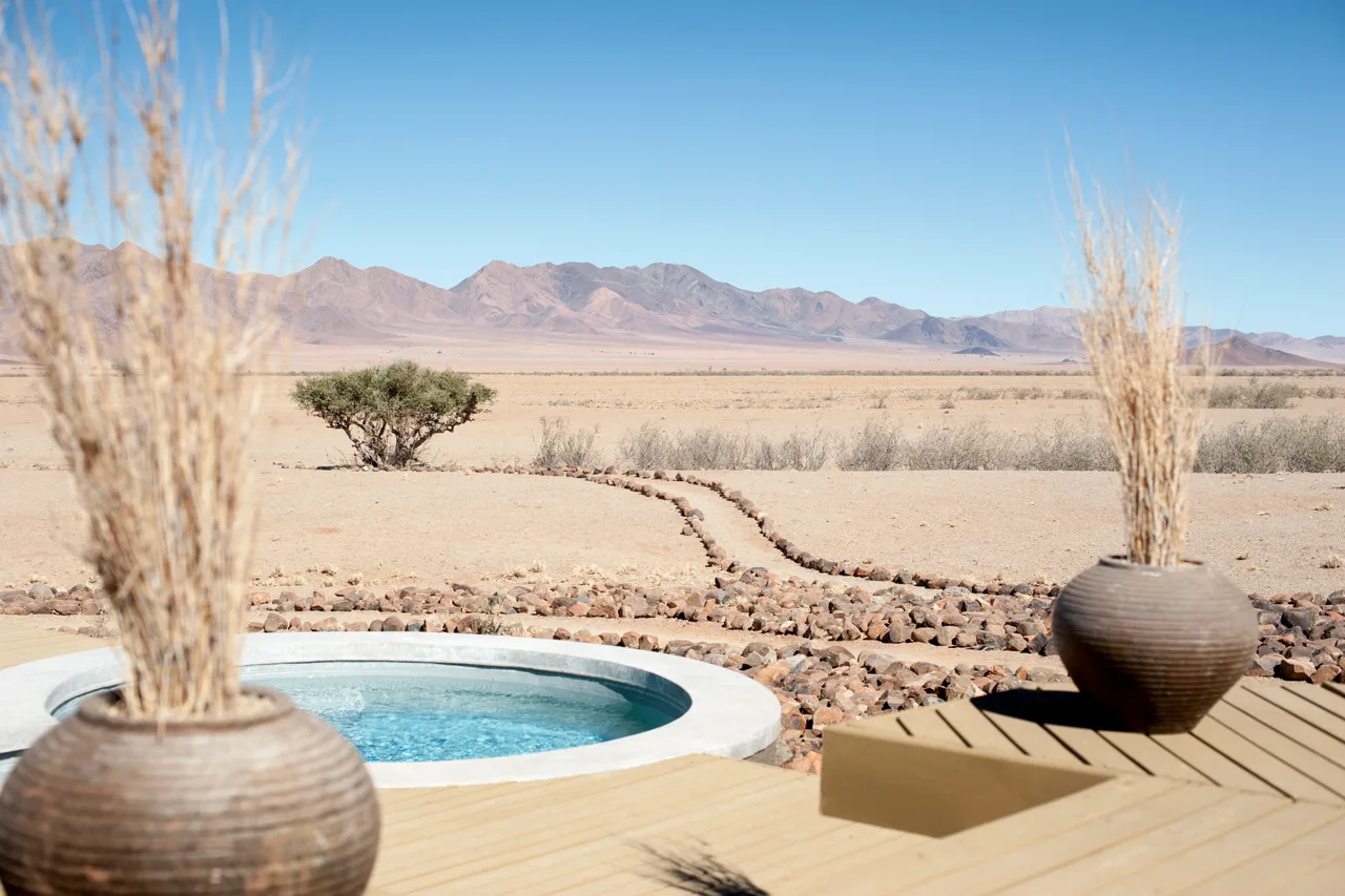 Une terrasse de camp ouverte sur les plaines et les montagnes du NamibRand.