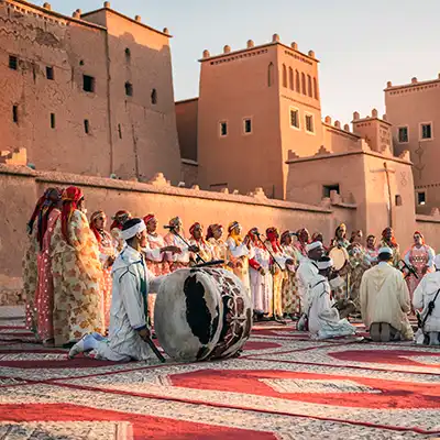 Cérémonie musicale traditionnelle devant les kasbahs en pisé du sud marocain, au coucher du soleil.